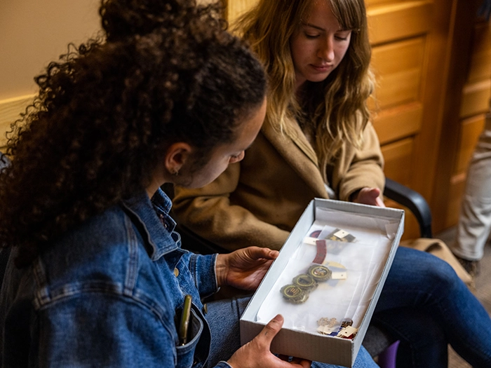 Group hikes through snowy forest toward mountain peaks.
