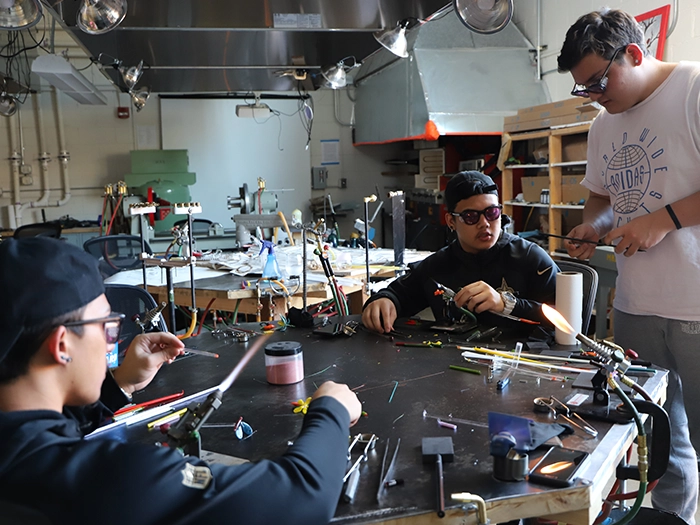 Students practice glass torchwork in a campus lab